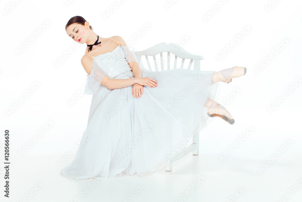Ballerina in white dress sitting, studio background. Ballerina in white dress sitting, studio background.