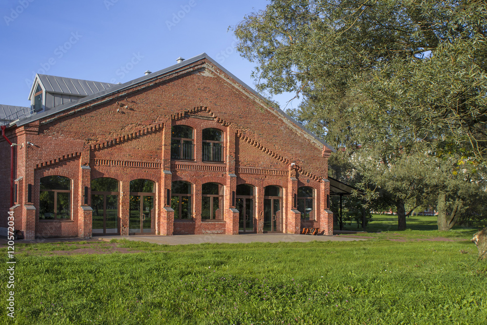 Red Brick Building with Large Windows behind Trees Red Brick Building with Large Windows behind Trees