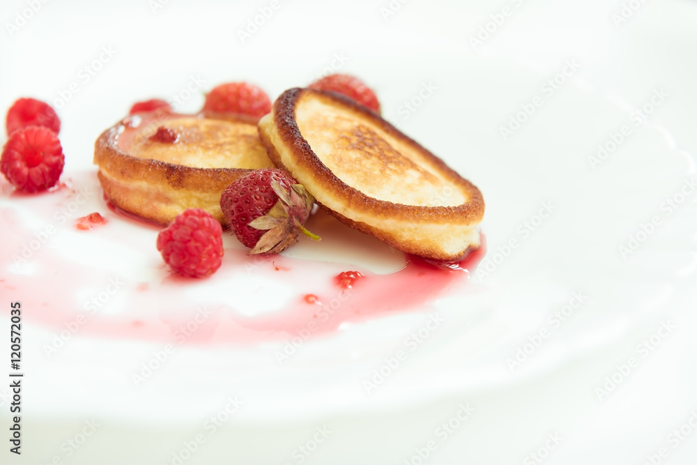 Pancakes with strawberry and raspberry jam on a white plate