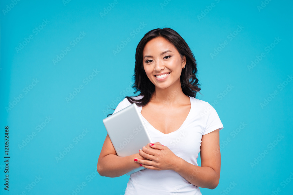Smiling young woman holding tablet computer and looking at camera Smiling young woman holding tablet computer and looking at camera