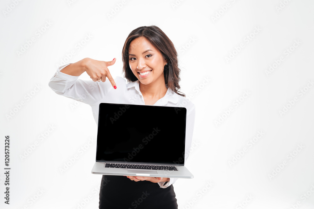 Smiling asian businesswoman pointing at laptop with blank screen Smiling asian businesswoman pointing at laptop with blank screen
