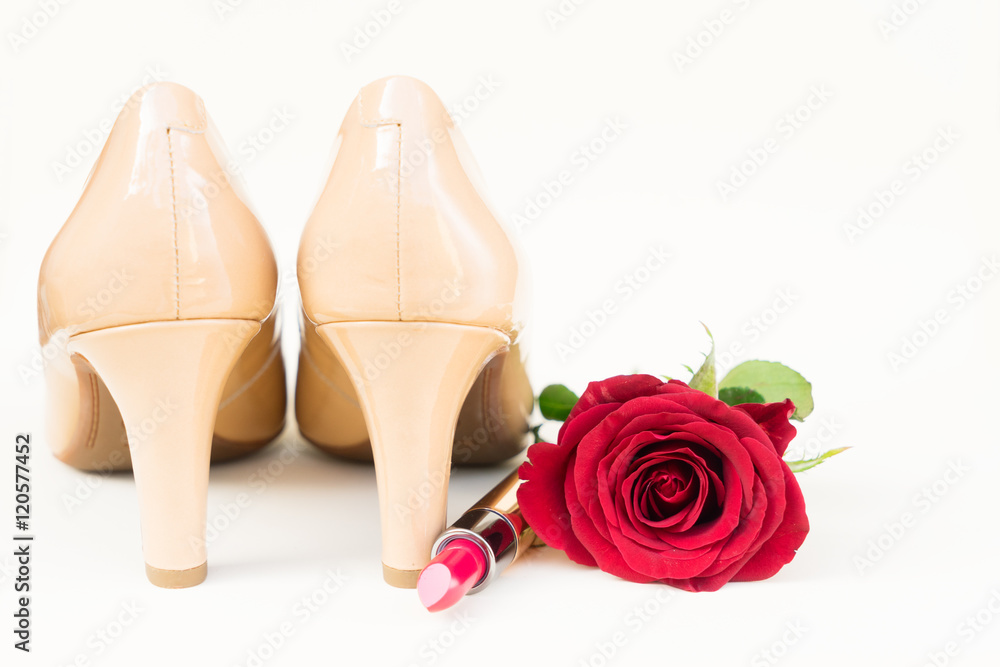 Nude colored high heels still life with red rose bud and lipstick Nude colored high heels still life with red rose bud and lipstick