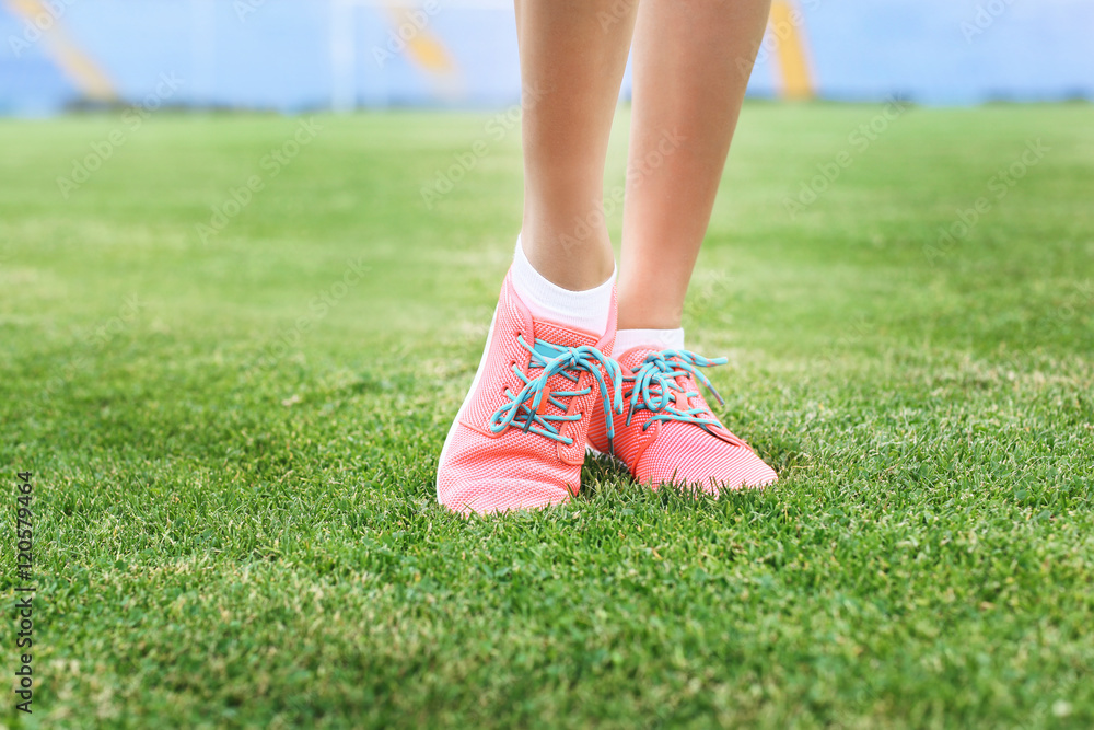 Woman wearing pink sneakers and standing on a grass