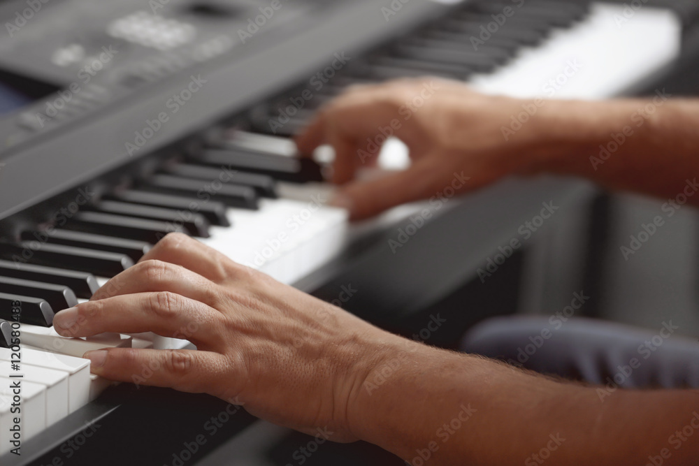 Obraz premium Male hands playing on synthesizer