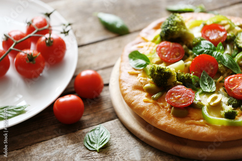 Plate with tasty vegetarian pizza on wooden table