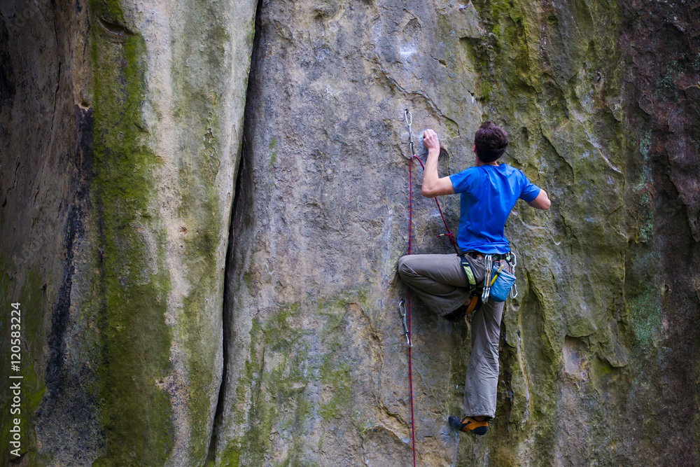 A rock climber climbs up the mountain. A rock climber climbs up the mountain.