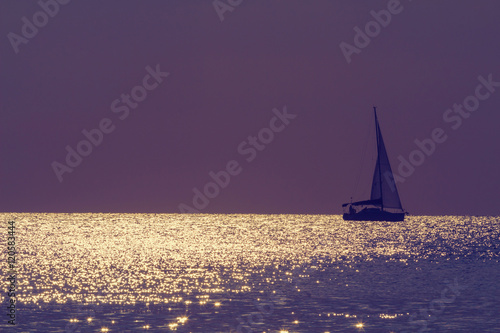 Boat floating on the sea in sunset.