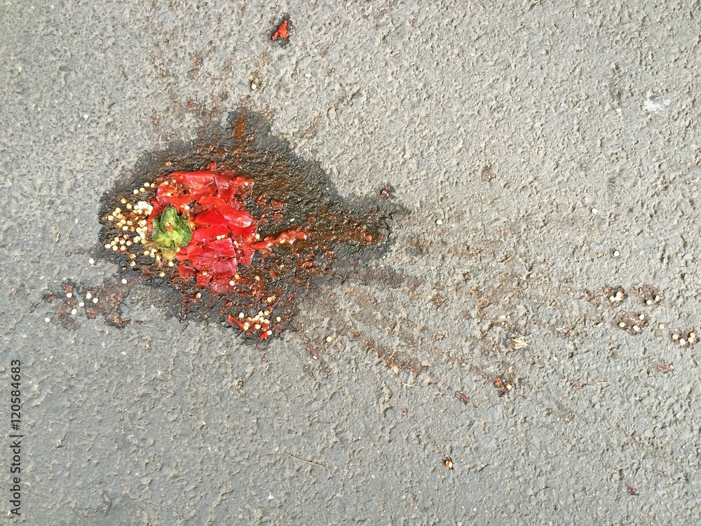 Squished red bell pepper on pavement background Squished red bell pepper on pavement background