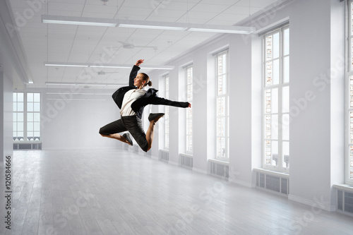 Dancing businesswoman in office . Mixed media photo