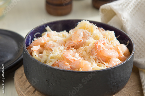 Pasta with shrimps, fettucine, olive oil, cream, cheese parmesan and spices in pan