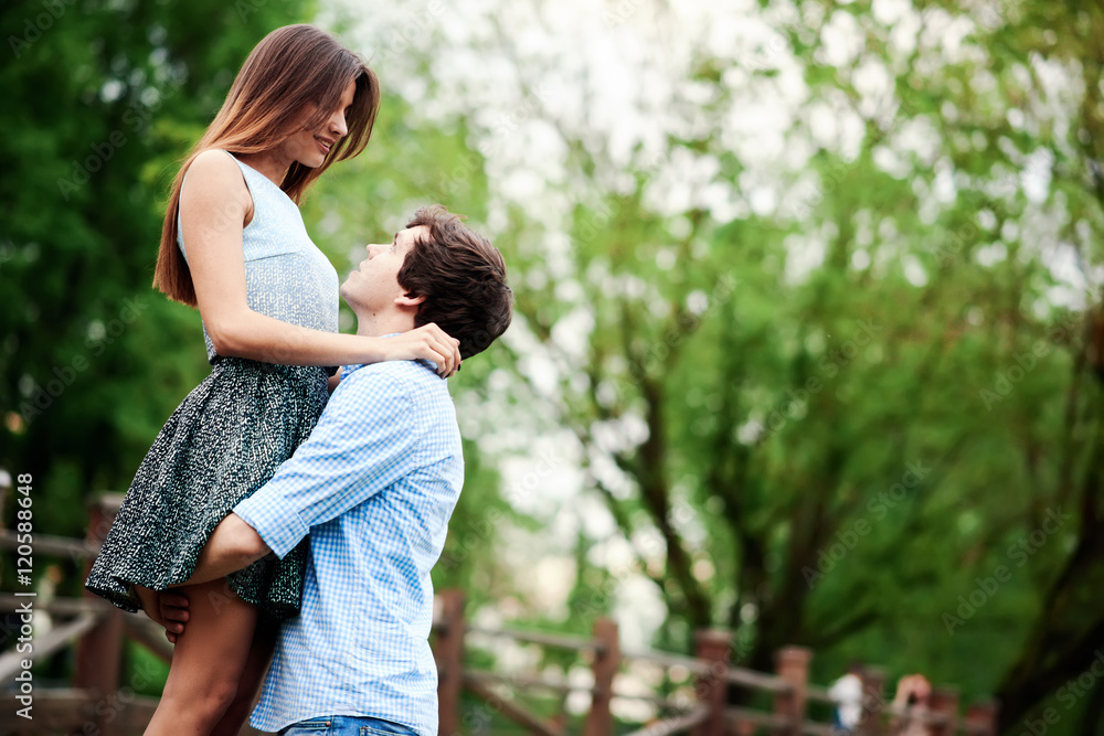 Young and happy couple embracing in the summer park in the city Young and happy couple embracing in the summer park in the city