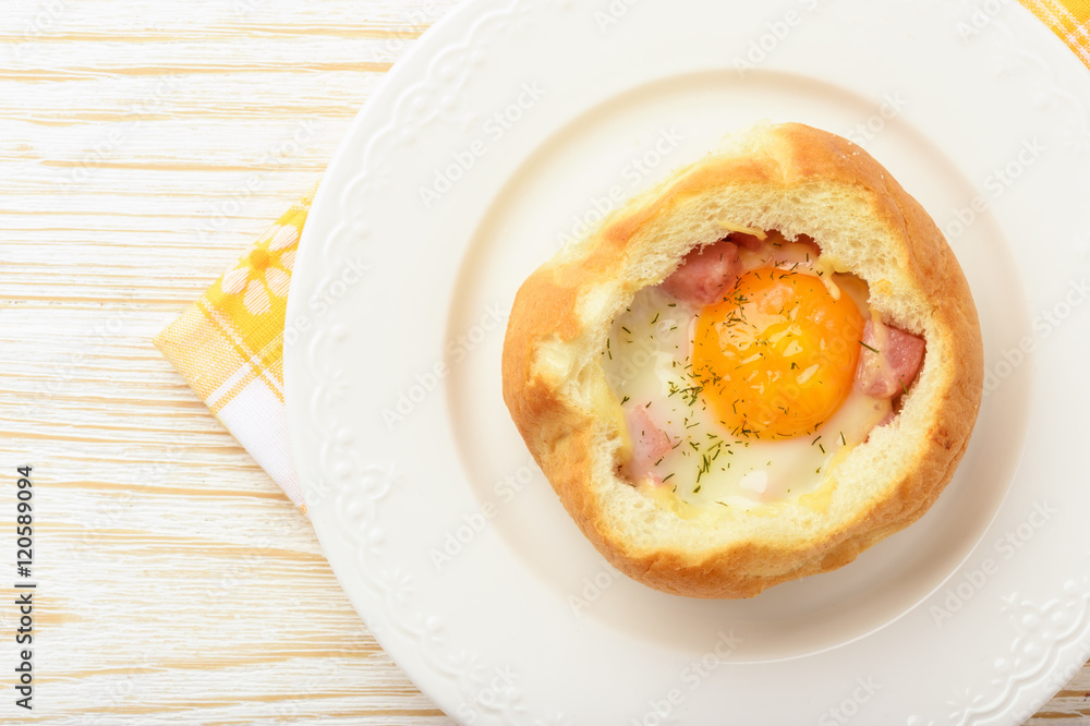 Bun baked with egg, cheese and ham on white wooden table. Bun baked with egg, cheese and ham on white wooden table.