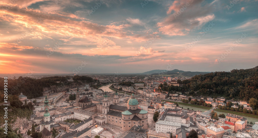 Fototapeta premium Aerial panoramic view of the historic city of Salzburg with Salzach river in beautiful golden evening light with blue sky and clouds at sunset in summer, Salzburger Land, Austria