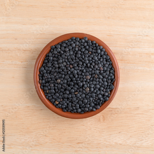 Black beluga lentils in a bowl on a table top view.