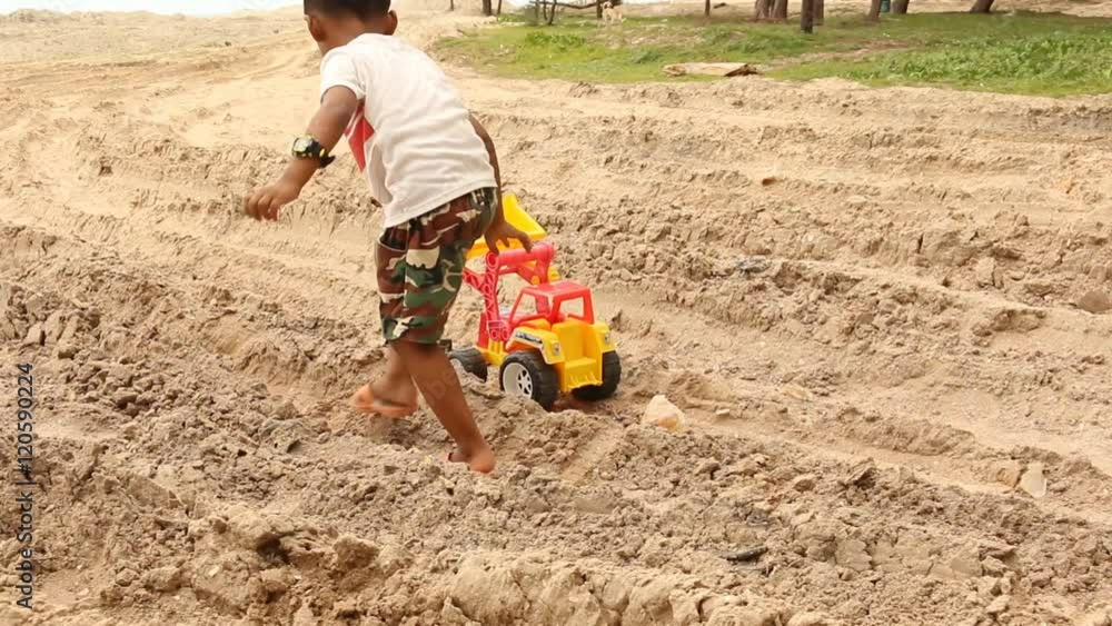 Cute little boy playing with car toys on beach Cute little boy playing with car toys on beach