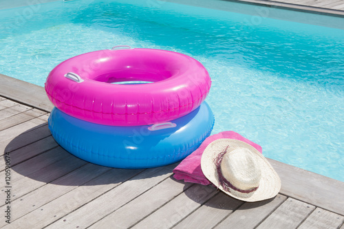 Colorful towel and blue and pink buoy near the pool photo