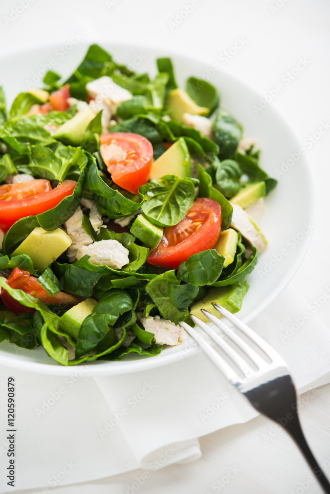 Fresh salad with chicken, tomatoes, spinach and avocado on white wooden background close up. Healthy food. Fresh salad with chicken, tomatoes, spinach and avocado on white wooden background close up. Healthy food.