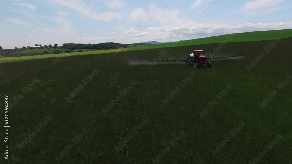 Aerial shot of tractor spraying grass seed farm Aerial shot of tractor spraying grass seed farm