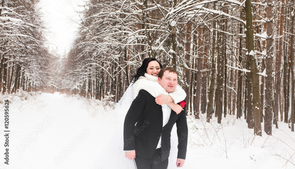 Man giving woman piggyback ride on winter vacation in snowy forest. Man giving woman piggyback ride on winter vacation in snowy forest.
