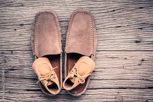 still life photography : father and child shoes on old wood in vintage color tone, go ahead together concept