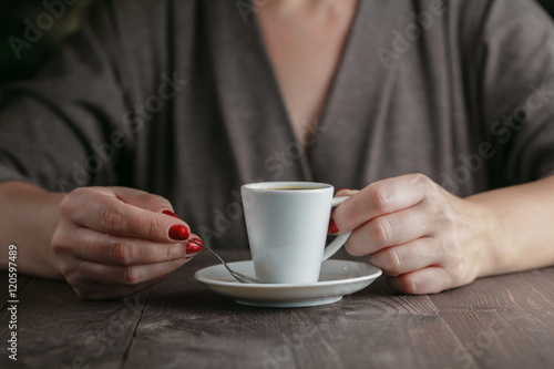 woman hands with espresso on a wood table