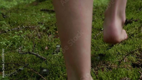 girl walks barefoot in the woods in a cloak