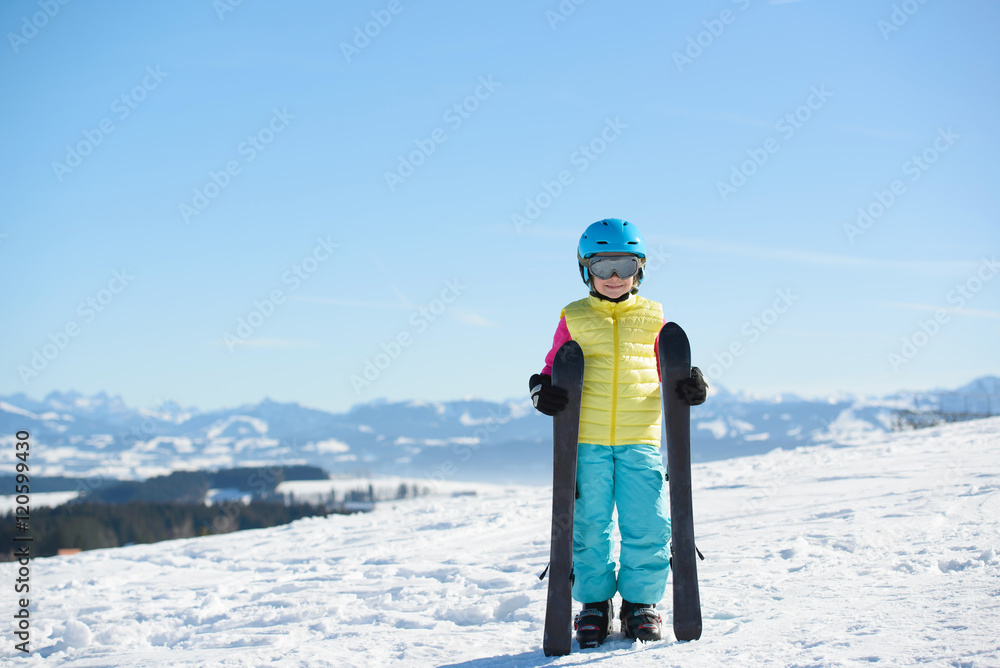 Smiling skier girl in the mountains on a sunny day