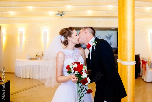 Newlyweds first kiss on wedding party.