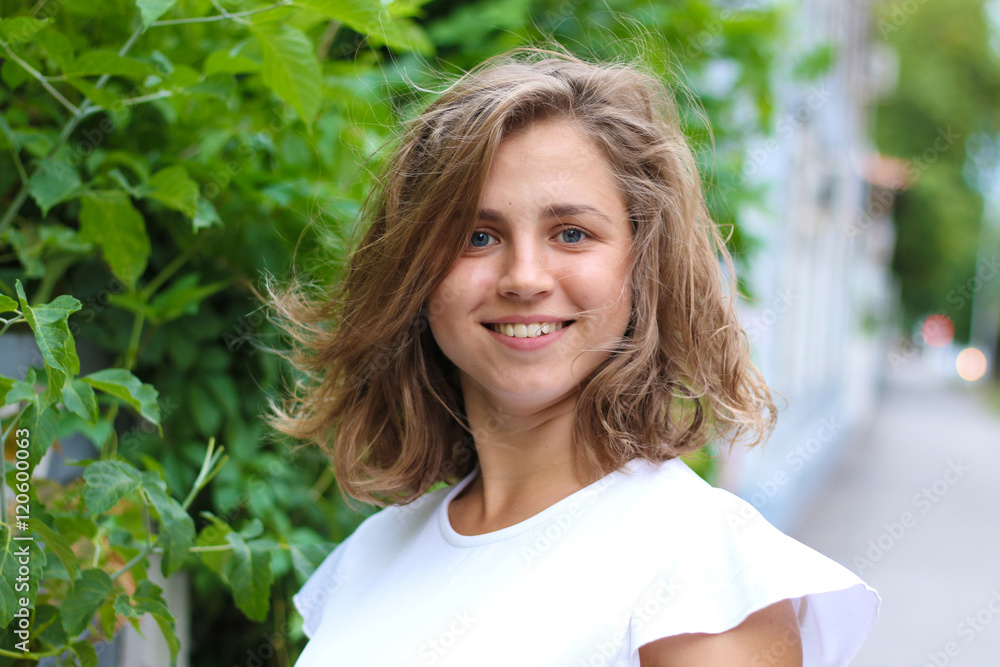Portrait of a young woman near a wall of leaves Portrait of a young woman near a wall of leaves