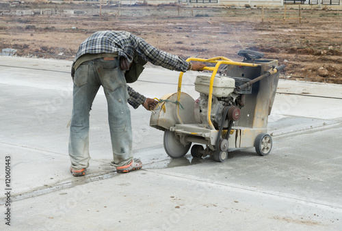 Labor construction worker using machine cutter joint concrete floor slab