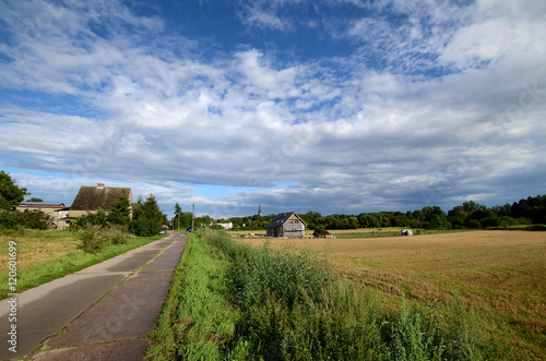Obraz na płótnie Country road under a cloudy sky w salonie
