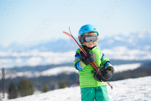 Portrait of a happy skier boy in the mountains during winter holiday