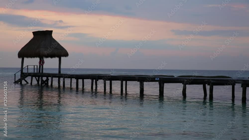 Woman walks along pier at tropical resort Woman walks along pier at tropical resort