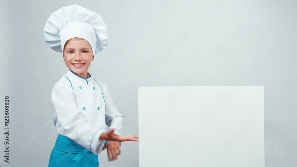 Chef cook child pointing to whiteboard and smiling at camera with teeth. Isolated on white background Chef cook child pointing to whiteboard and smiling at camera with teeth. Isolated on white background