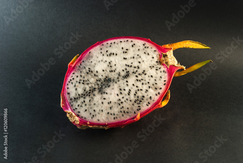 Dragon fruit cut in half on a black background closeup