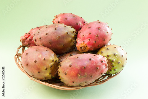 prickly pear (opuntia) fruits in the wicker plate closeup on gre
