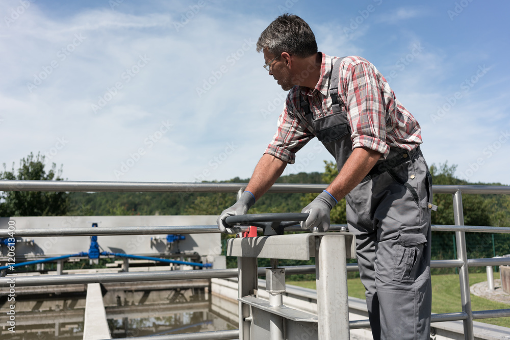 Worker opening valve in tank system of sewage treatment plant Worker opening valve in tank system of sewage treatment plant