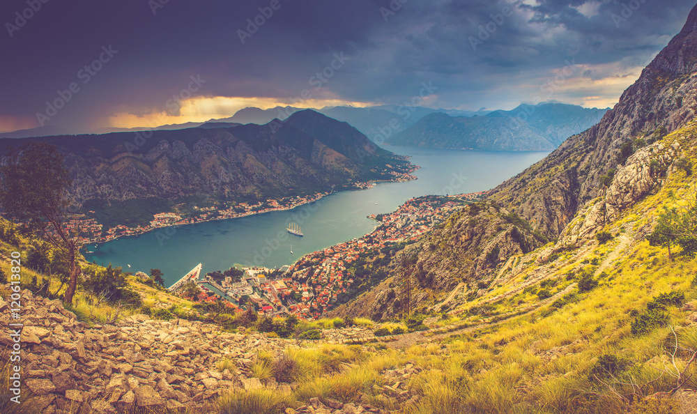 Panoramic landscape of mountain ridge with path descends down and Kotor bay at distance.