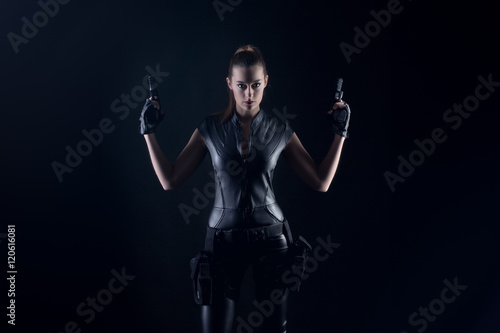 Superhero woman in a leather catsuit holding guns