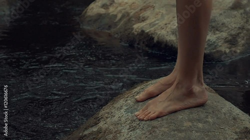 girl walks barefoot in the woods in a cloak