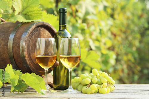 Fototapeta Naklejka Na Ścianę i Meble -  Wine in glasses with bunch of grape on wooden table