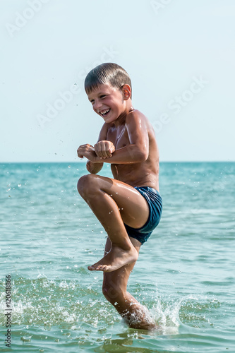 Healthy boy jumping in water