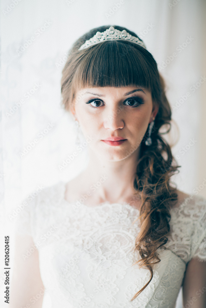 portrait of a young bride standing near window portrait of a young bride standing near window