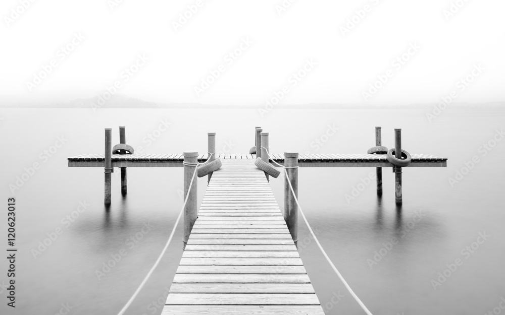 Wooden pier on the lake. Fog. Long exposure. Black and White.