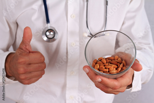Vitamin b 17. Cancer prevention concept, alternative medicine. Doctor holding Apricot Kernels / seeds close up