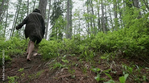 young girl walking in the woods one barefoot