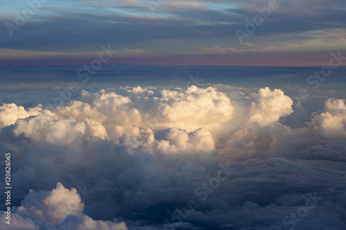 Aerial view of thick clouds over the land, the landscape. The texture of the scenic sky during sunset.