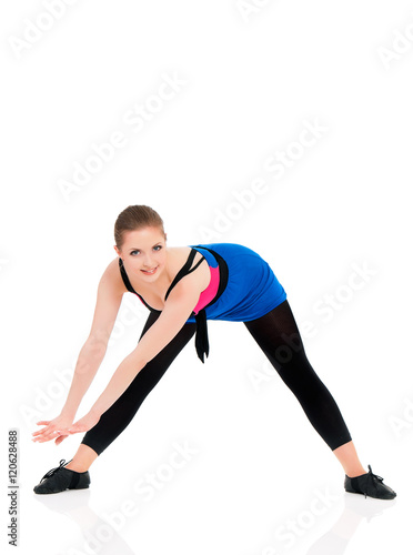 Healthy lifestyle - full length portrait of smiling young fitness girl in perfect shape. Sporty caucasian female model isolated on white background. Cheerful young woman doing stretch exercise. 