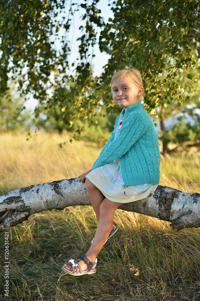 petite fille assise sur une branche