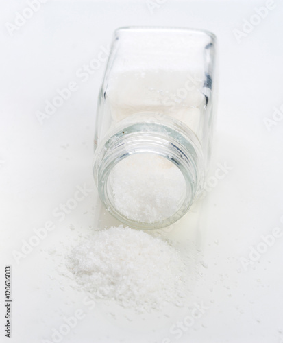 macro takes salt out of a fallen saltshaker, isolated